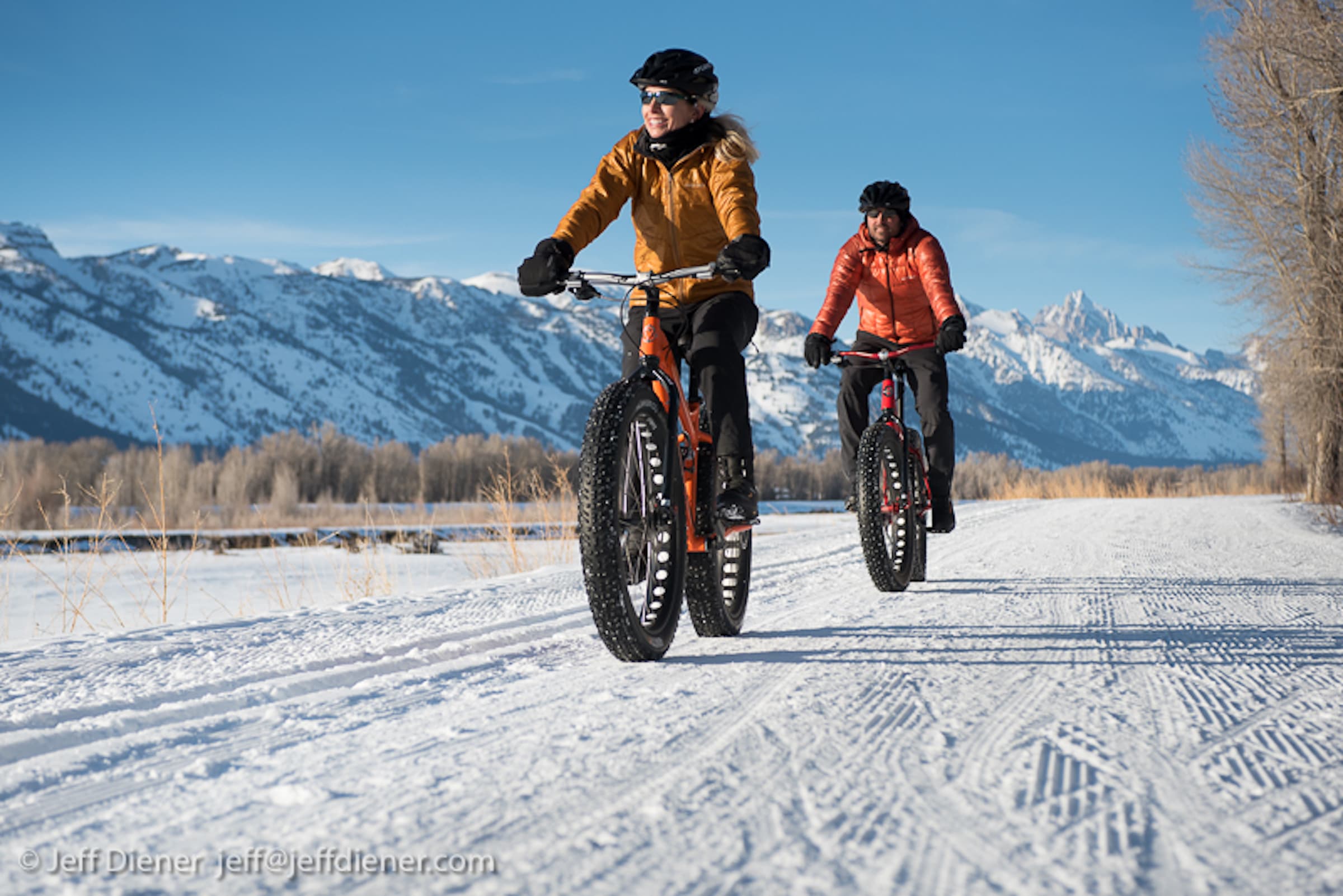 A couple winter fat biking over the snow in Jackson Hole, Wyoming.