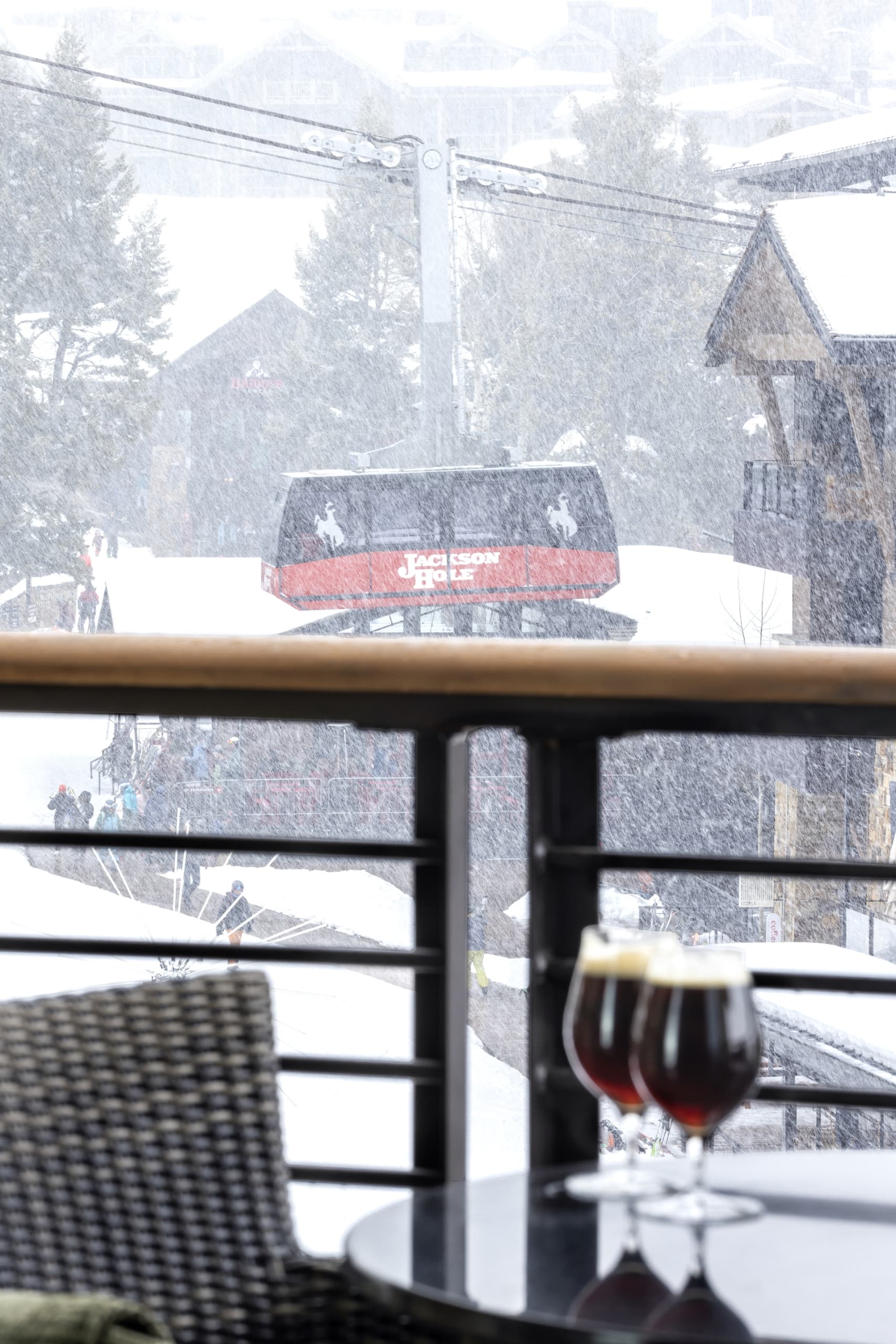 A balcony with 2 glasses of red wine on a table and a tram view at Hotel Terra