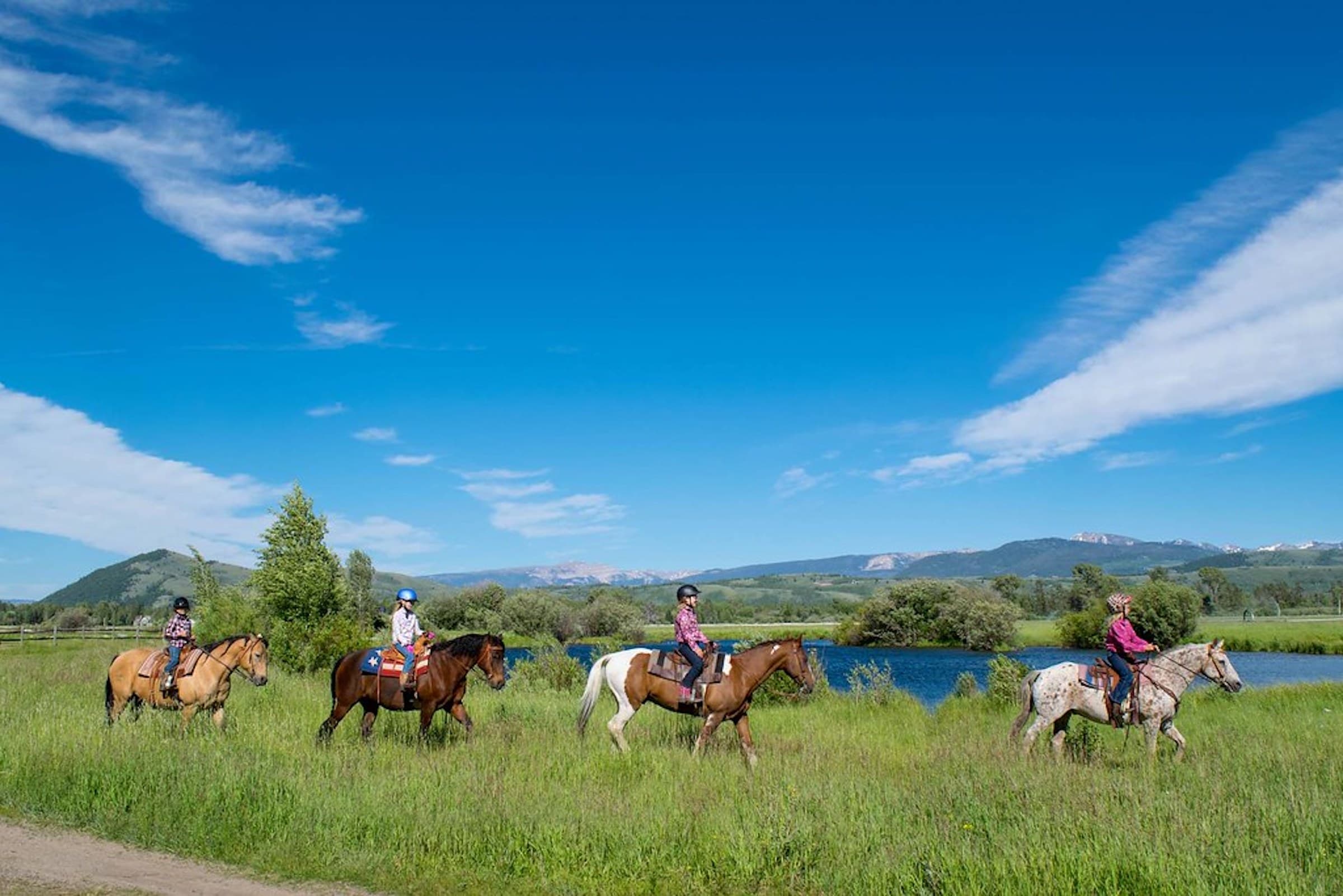 A group of children enjoying a horseback riding experience in Jackson Hole, Wyoming.