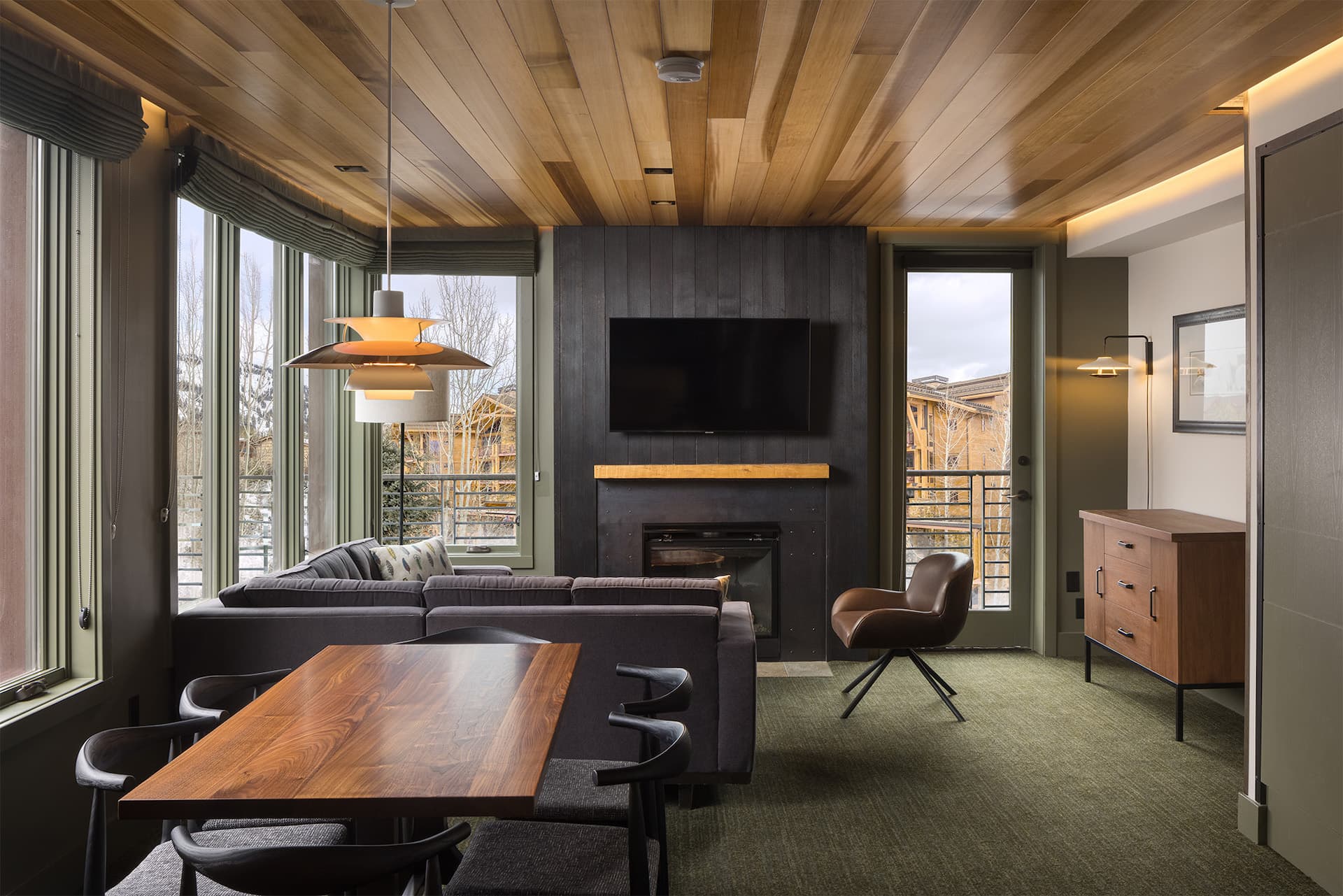 Living space inside a room at Terra Hotel with a table for 6 and a fireplace with a sofa and chair