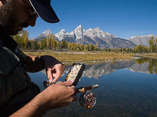 Guy fly fishing with the Tetons in the background.